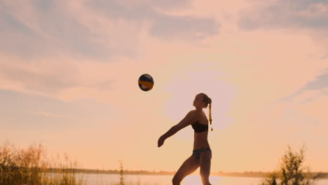Group-of-young-girls-playing-beach-volleyball-during-sunset-or-sunrise-slow-motion.-Beautiful-girls-in-bikini-professionally-play-volleyball-on-the-sand